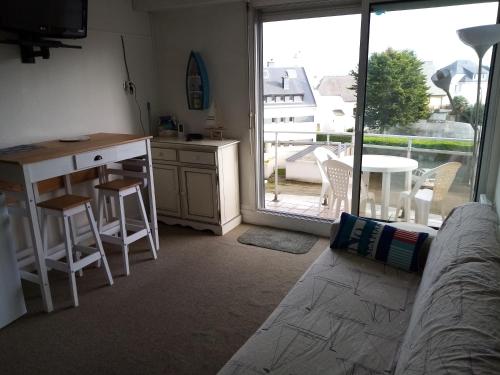 Il comprend un salon avec un canapé et une cuisine avec un balcon. dans l'établissement studio résidence le sombreuil, à Quiberon