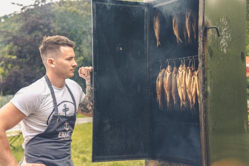 a man standing next to a box of meat at Landgasthof & Restaurant Batzenhäusl in Sankt Gilgen