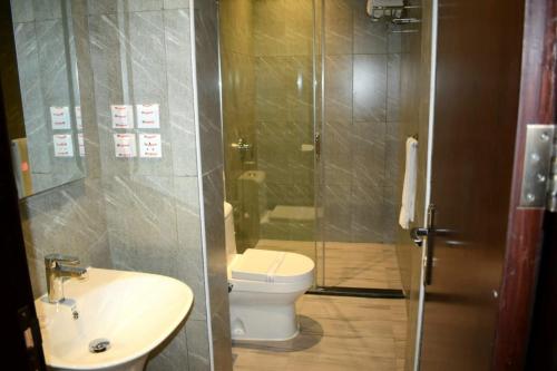 a bathroom with a toilet and a sink and a shower at Hotel & Resort Golden Marina Yanbu in Yanbu