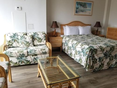 een hotelkamer met een bed en een bank bij Ilikai Marina Studio City View Condos with Fully Equipped Kitchens & Free Wifi in Honolulu