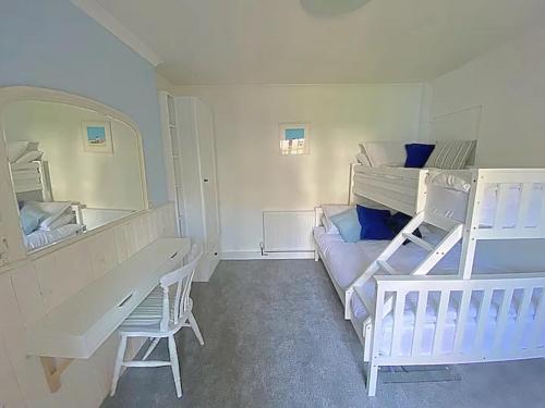 a bedroom with two bunk beds and a desk and a mirror at The Retreat @ The Old Smithy, Colebrook Village in Plymouth