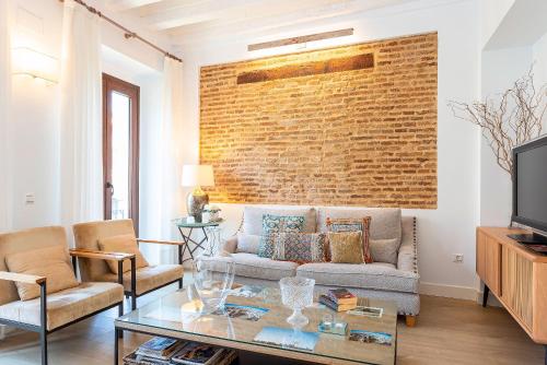 a living room with a couch and a brick wall at Genteel Home Julio César in Seville