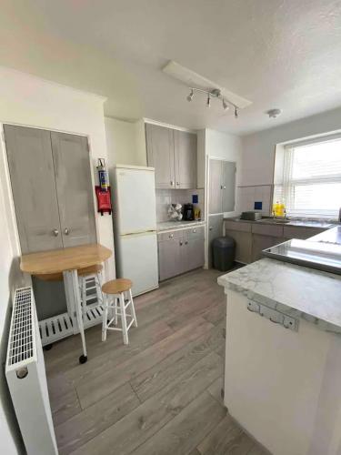a kitchen with a white refrigerator and a wooden floor at The Retreat @ The Old Smithy, Colebrook Village in Plymouth