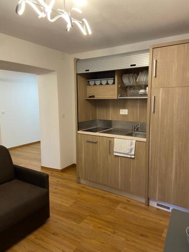 a kitchen with a sink and a couch in a room at B&B Berninapass in Poschiavo
