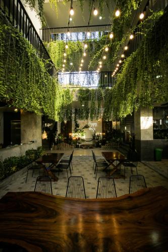 a patio with tables and chairs and plants at Fati Boutique Hotel & Apartment in Vung Tau