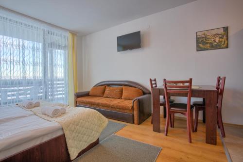 een slaapkamer met een bed, een tafel en een stoel bij Bright Studio in a Spacious Complex in the Valley by Flat Mаnager in Bansko