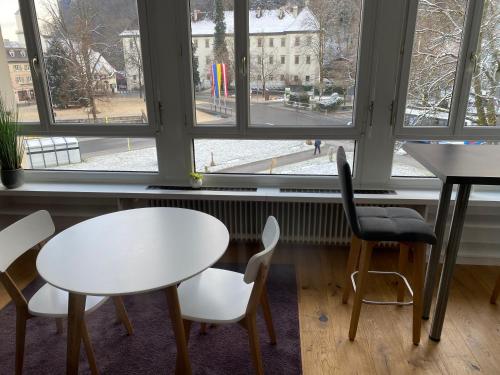 a table and chairs in front of a window at Zimmer & Appartements am Schloßplatz in Hohenems