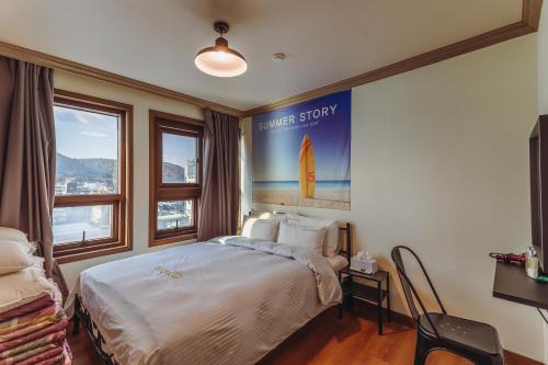 a bedroom with a bed and a poster on the wall at Residence Hotel Blue Ocean View in Ulsan
