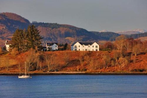 a house on a hill next to a body of water at One The Cairns in Connel