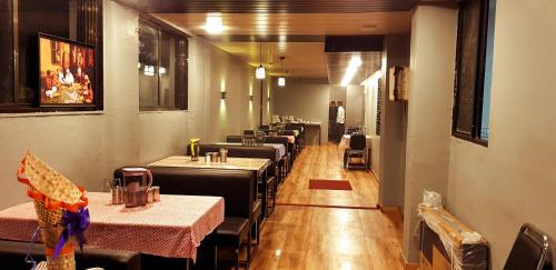 un comedor con mesas y sillas en un restaurante en Blueberry Budget Hotel, en Shirdi