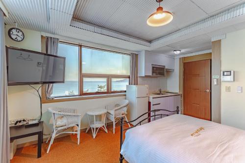 a bedroom with a bed and a table and chairs at Residence Hotel Blue Ocean View in Ulsan
