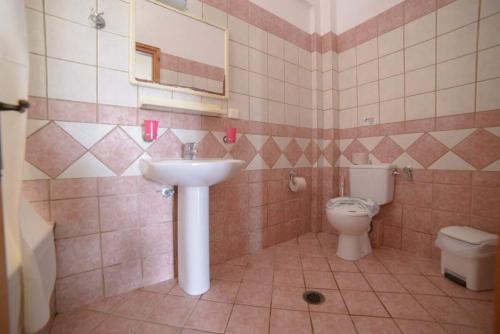 a bathroom with a sink and a toilet at Socrates Hotel in Sidari