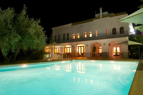 a swimming pool in front of a building at night at Villa Turística de Laujar de Andarax in Laujar de Andarax