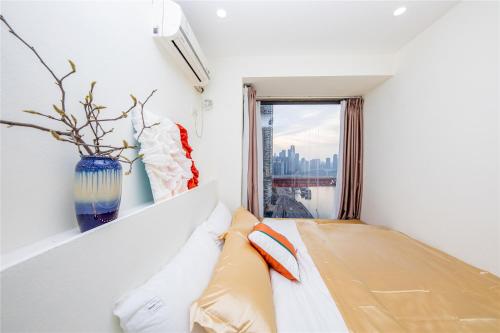 a room with a bed with a vase on the wall at Baihong Riverview Apartment-Hongya Cave in Chongqing