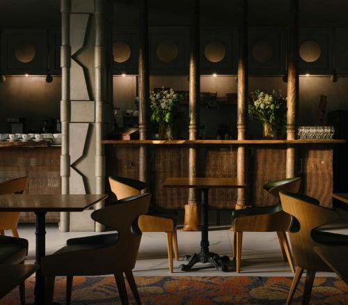 a restaurant with tables and chairs in a room at Brim Hotel in Tbilisi City