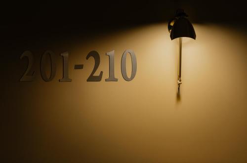 a lamp on a wall with a sign at Brim Hotel in Tbilisi City