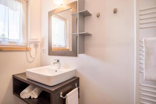 a bathroom with a white sink and a mirror at Apartment Ot Residence Bun Sté in San Vigilio Di Marebbe
