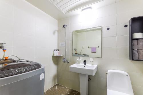 a white bathroom with a sink and a mirror at Residence Hotel Blue Ocean View in Ulsan