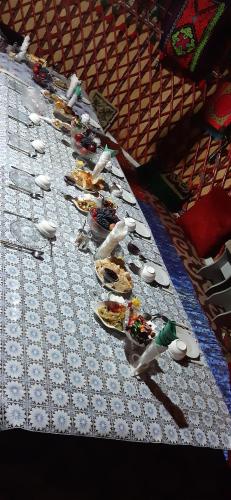 a long table with plates of food on it at Guesthouse Kishimzhan in Talas