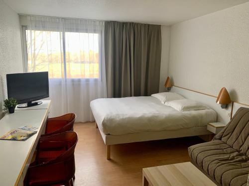 Lorient Résidence في Caudan: غرفه فندقيه بسرير واريكه