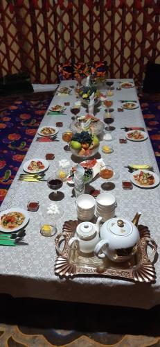 a table with plates of food on it at Guesthouse Kishimzhan in Talas