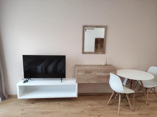 uma sala de estar com uma televisão e uma mesa e cadeiras em Studio 16A Vasil Aprilov 64 - Plovdiv em Plovdiv