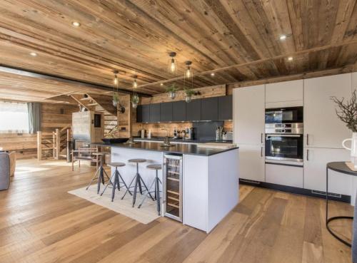 une cuisine avec des armoires blanches et un plafond en bois dans l'établissement Chalet Les Gets Neko, aux Gets