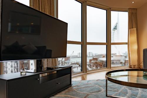 a living room with a large television and a large window at GWQ Apartments Luxe in Portsmouth
