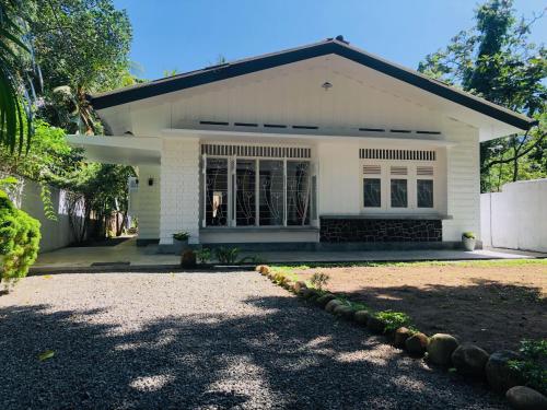 Mahagedara Dickwella في ديكويلا تين: منزل أبيض أمامه ممر
