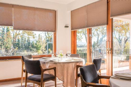 a dining room with a table and chairs and windows at Hotel Emporda in Figueres