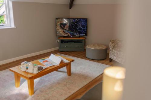 a living room with a coffee table and a tv at Corffe House and Holiday Cottages in Barnstaple
