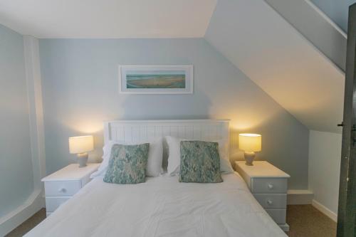 a bedroom with a white bed with two lamps at Corffe House and Holiday Cottages in Barnstaple