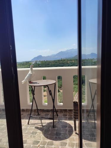 a bird sitting on a table on a balcony at Natural Green Apartment in Dhamnóni