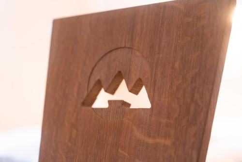 a close up of a wooden sign with two arrows at Brunarica in Bohinj