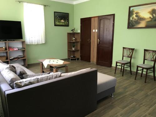 Vénusz Üdülőcentrum في Tiszacsege: غرفة معيشة مع أريكة وطاولة وكراسي