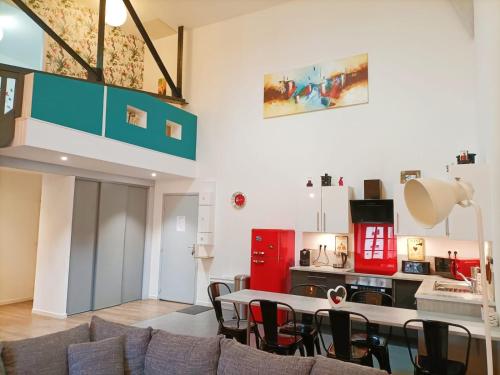 een woonkamer met een tafel en stoelen en een keuken bij Superbe appartement type loft en duplex rue Buat in Châlons-en-Champagne