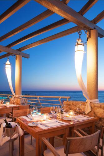 a restaurant with a table with the ocean in the background at Hotel Dubrovnik Palace in Dubrovnik