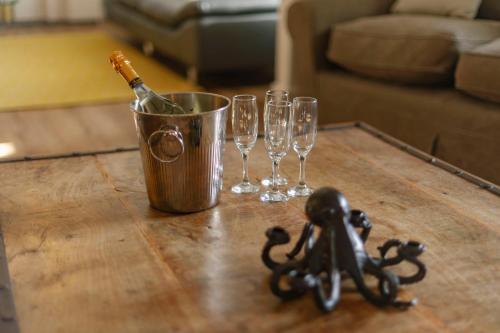 a bucket with a bottle of champagne and wine glasses on a table at Corffe House and Holiday Cottages in Barnstaple