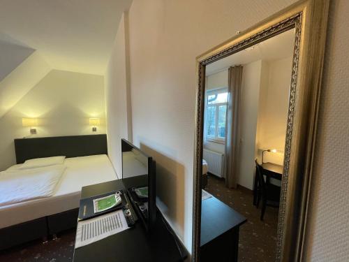 a hotel room with a bed and a mirror at dS Hotel Gronau in Gronau