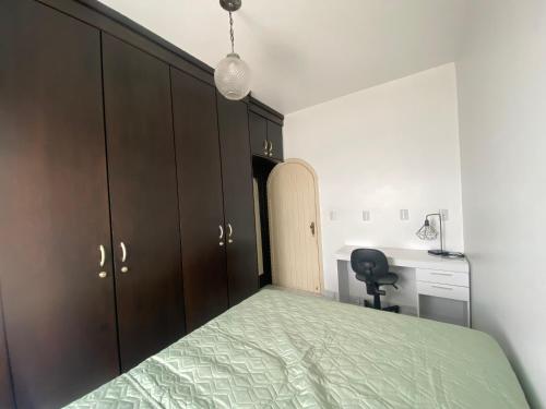 a bedroom with a green bed and a desk at Quarto Residencial320 - Timbó in Timbó
