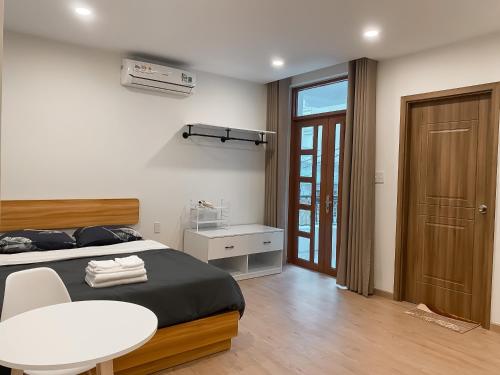 ein Schlafzimmer mit einem Bett, einem Tisch und einem Stuhl in der Unterkunft B786 Airport Apartment in Ho-Chi-Minh-Stadt