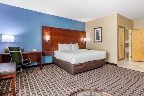 een hotelkamer met een groot bed, een bureau en een bureau bij Comfort Suites in Georgetown
