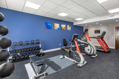 a gym with exercise bikes and a blue wall at Comfort Suites St Louis - Sunset Hills in Saint Louis
