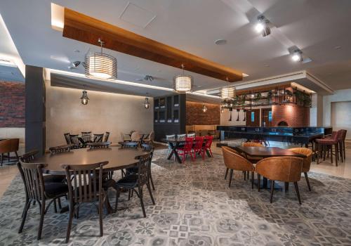 a restaurant with tables and chairs and a bar at Radisson Resort Ras Al Khaimah Marjan Island in Ras al Khaimah