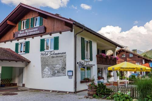 un bâtiment avec un panneau sur son côté dans l'établissement Hotel Pension Schwansee, à Schwangau