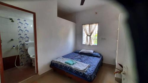 マハーバリプラムにあるElis Homestayのベッドとシャワーのある小さな寝室