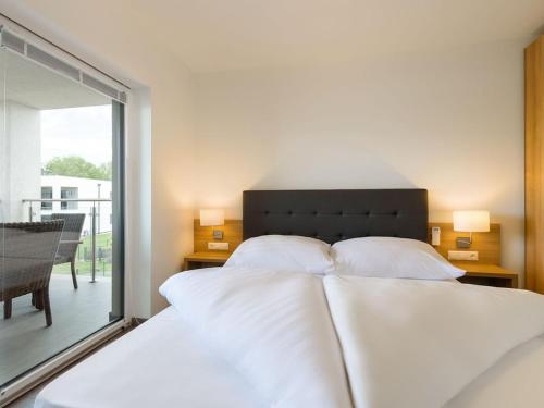 sypialnia z łóżkiem z białą pościelą i oknem w obiekcie Relaxing Apartment Stay in Zsira w mieście Zsira