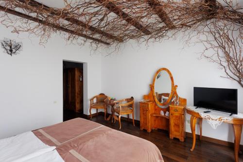 a bedroom with a bed and a desk with a television at Conacul Archia in Deva