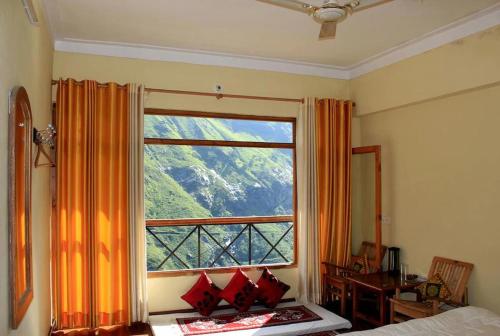 sypialnia z oknem z widokiem na góry w obiekcie Abode Luxurious stay w mieście Jyotirmath