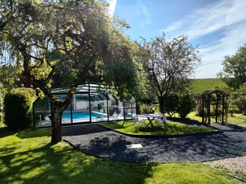 une maison avec une piscine et un arbre dans l'établissement Domaine l'instant du Colibri, à Le Mesnil-Théribus